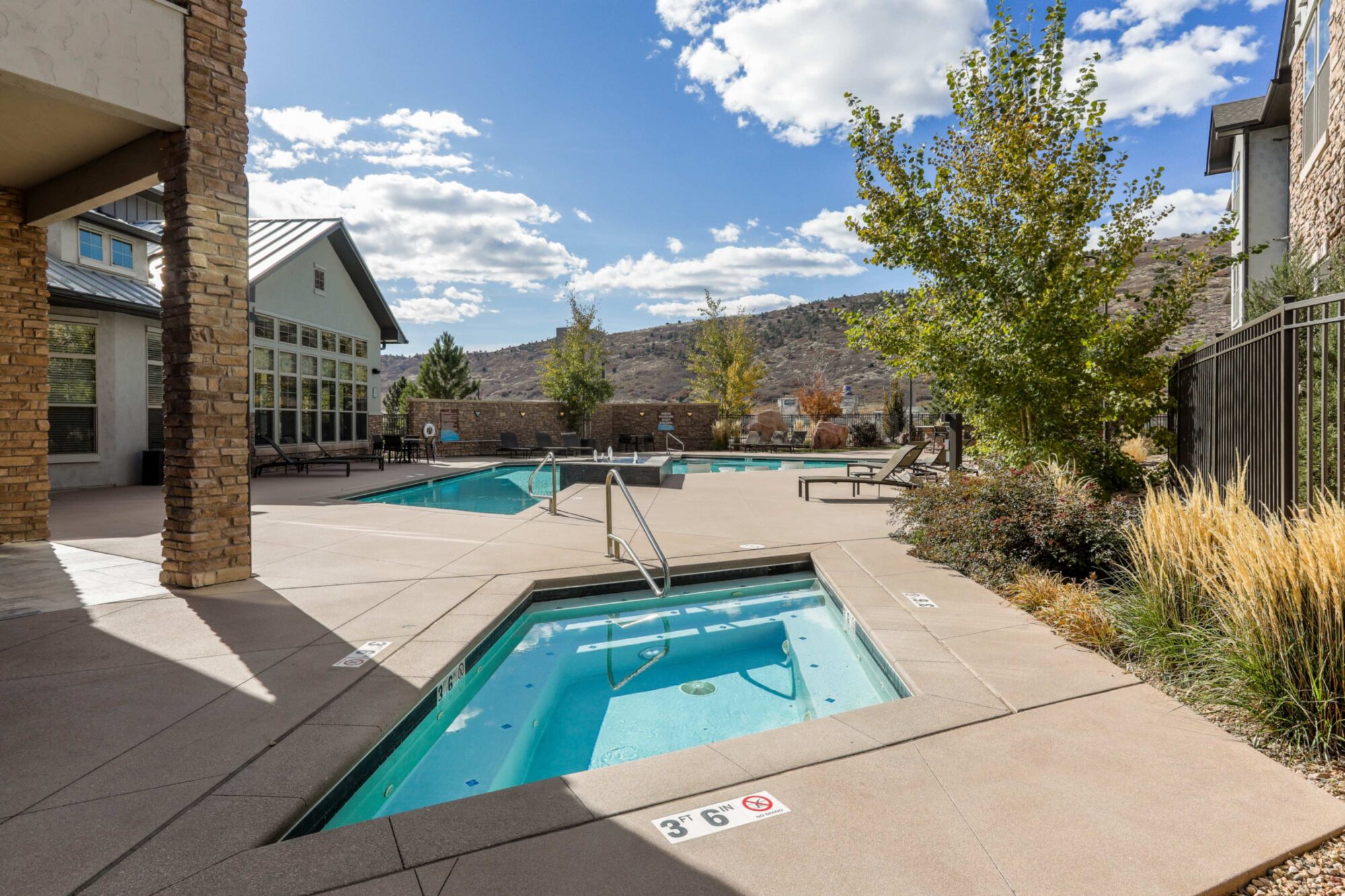 Pool and spa with deck seating and mountain views.